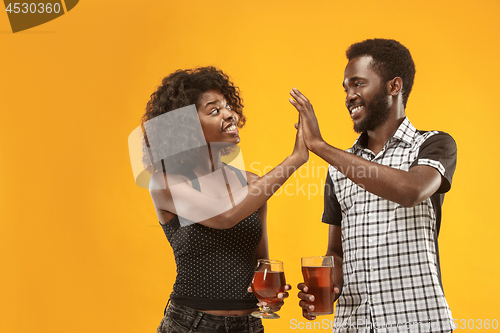 Image of The afro couple or happy young people laughing and drinking beer at studio