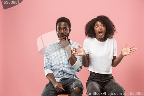 Image of Couple surprised watching sports match on tv at home, successful game