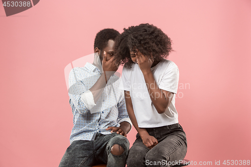 Image of Couple surprised watching sports match on tv at home, unsuccessful game