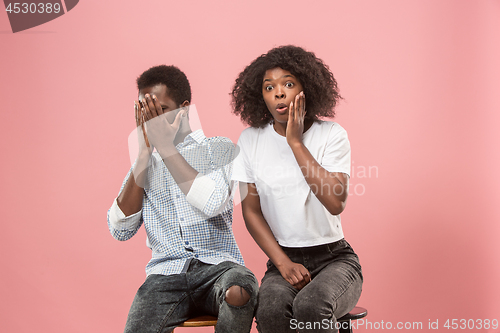 Image of Couple surprised watching sports match on tv at home, unsuccessful game