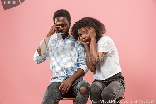 Image of Couple surprised watching sports match on tv at home, unsuccessful game