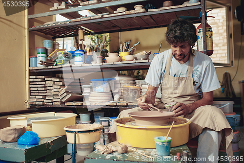 Image of Creating a jar or vase of white clay close-up. Master crock.