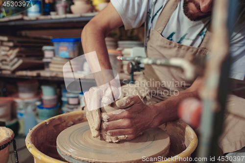 Image of Creating a jar or vase of white clay close-up. Master crock.