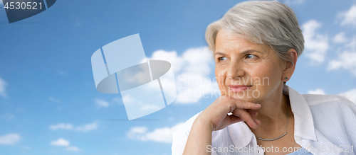 Image of portrait of pensive senior woman over blue sky