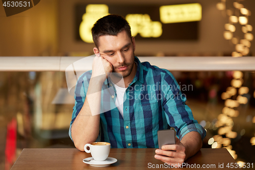 Image of man with coffee and smartphone at restaurant