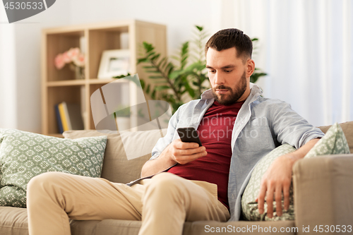 Image of man using smartphone at home