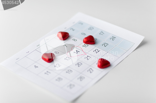 Image of close up of calendar and heart shaped candies