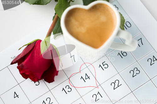 Image of close up of calendar, heart, coffee and red rose