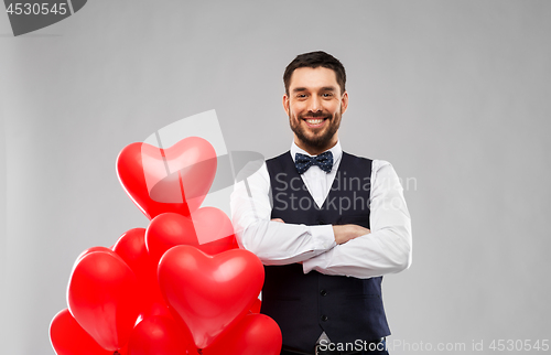 Image of happy man with red heart shaped balloons