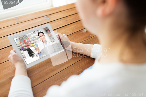 Image of woman having video chat with pharmacist on tablet