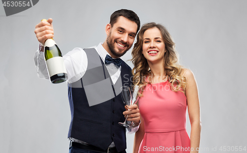 Image of happy couple with bottle of champagne and glasses