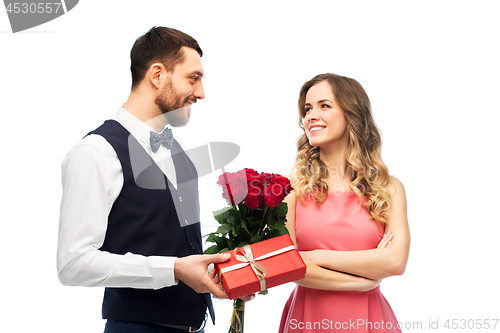 Image of happy man giving woman flowers and present