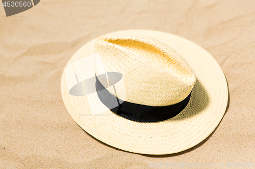 Image of straw hat on beach sand