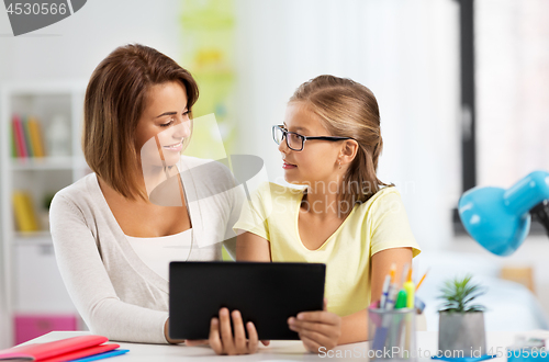 Image of mother and daughter with tablet pc doing homework