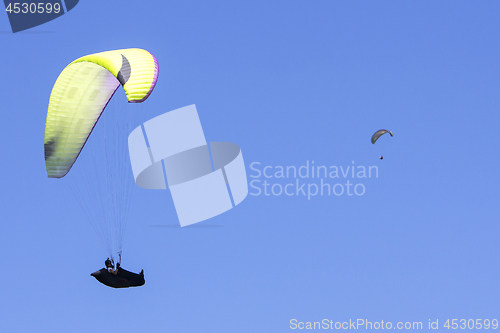 Image of Paragliding in the blue sky as background extreme sport