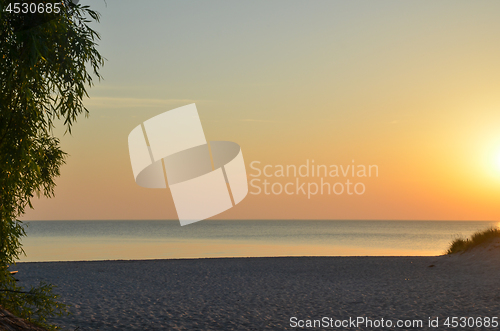 Image of Sunset by a beautiful empty sand beach