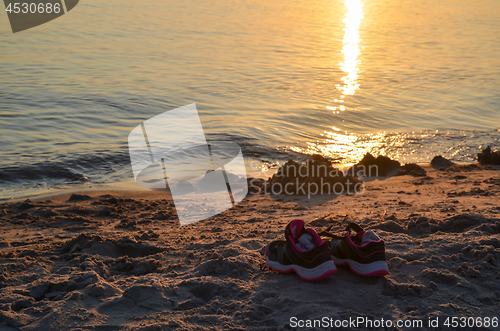 Image of Shoes by seaside on a sandy beach