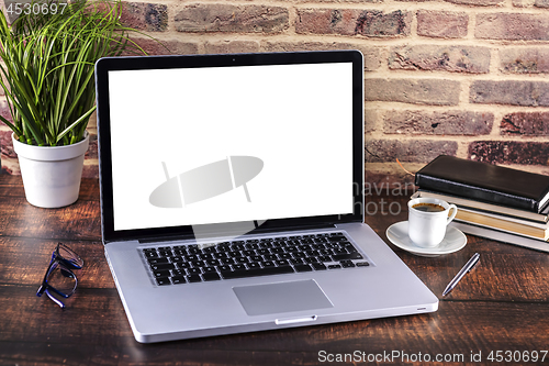 Image of Laptop notebook with blank screen and cup of coffee and notepad 