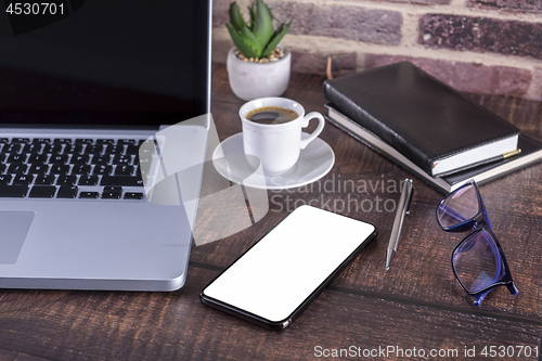 Image of Laptop notebook with blank screen and cup of coffee and notepad 