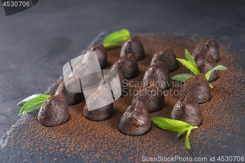 Image of Homemade chocolate truffles with mint sprinkled with cocoa powde