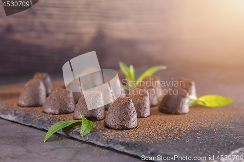 Image of Homemade chocolate truffles with mint sprinkled with cocoa powde