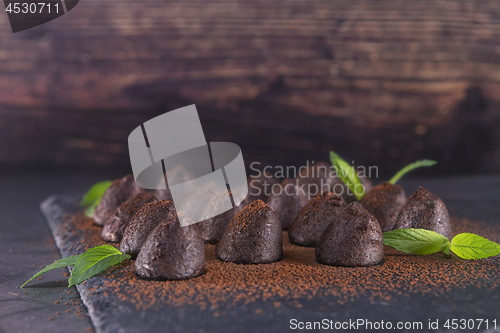 Image of Homemade chocolate truffles with mint sprinkled with cocoa powde