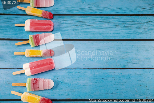 Image of Colorful fruit ice cream stick look fresh to eat placed on a blu