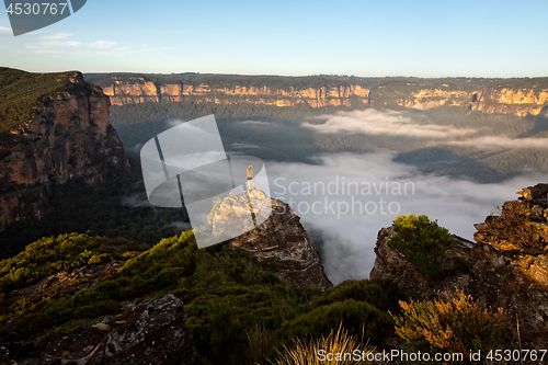 Image of Hiker taking in magnificent views of mountains and valleys as th