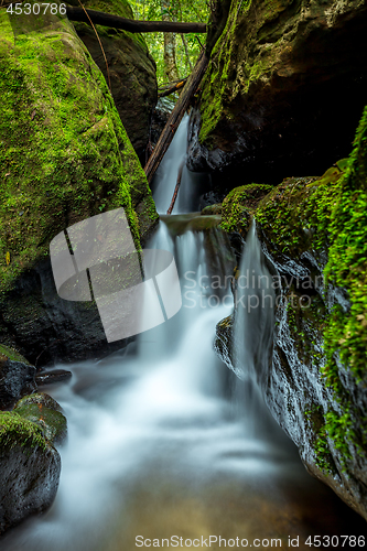 Image of Waterfall through the rock chasm in mountain gully 