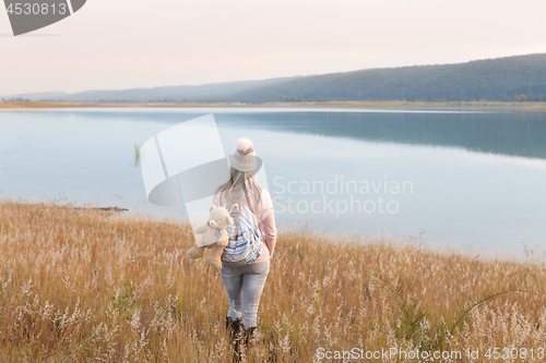 Image of Woman in long soft grasses by lake Country Life