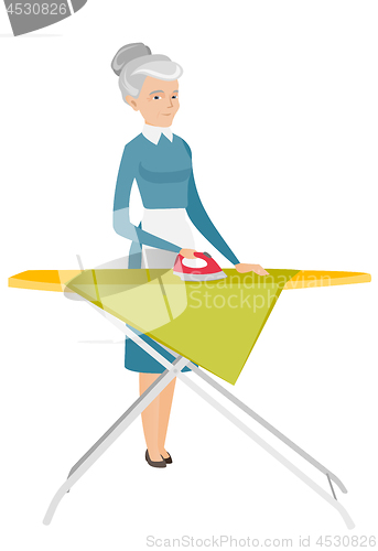 Image of Caucasian maid ironing clothes on ironing board.
