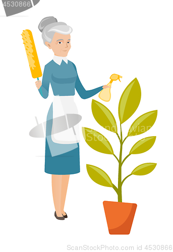 Image of Caucasian housemaid watering flower with spray.