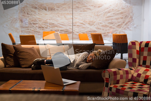 Image of woman sleeping on a sofa  in a creative office