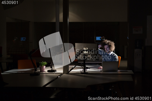 Image of man working on computer in dark office