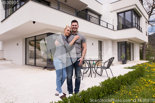 Image of couple hugging in front of  new luxury home