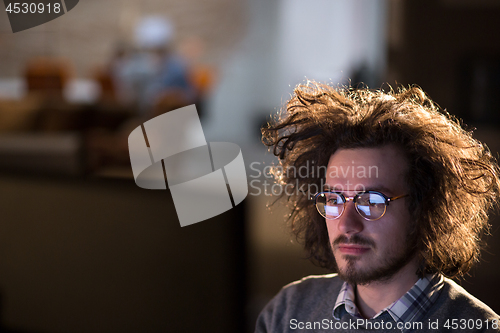 Image of man working on computer in dark office