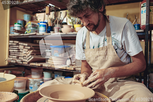 Image of Creating a jar or vase of white clay close-up. Master crock.