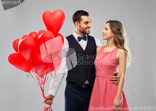 Image of happy couple with red heart shaped balloons