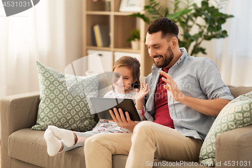 Image of father and daughter having video call on tablet pc