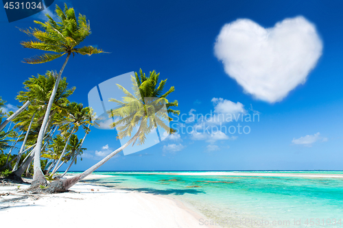 Image of romantic beach with palms and heart shaped cloud