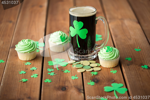 Image of shamrock on glass of beer, green cupcake and coins