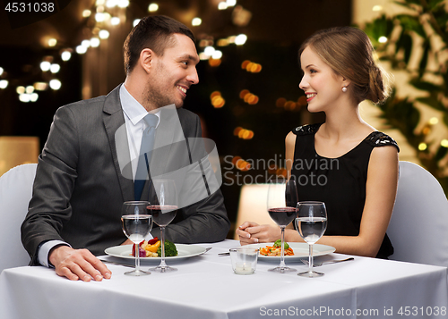 Image of couple with food and red wine at restaurant