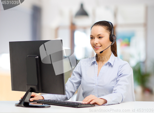 Image of helpline operator in headset working at office