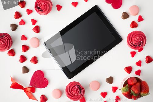 Image of close up of tablet pc and sweets on valentines day