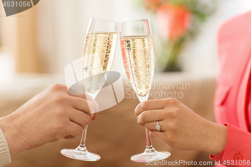 Image of close up of couple clinking champagne glasses