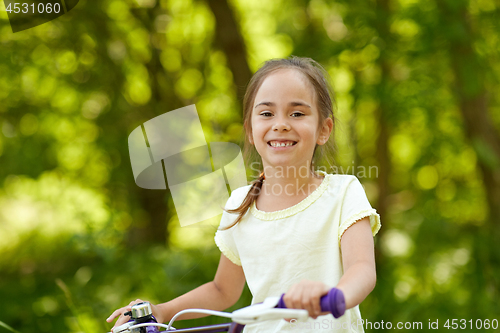 Image of happy little girl with bicycle in summer