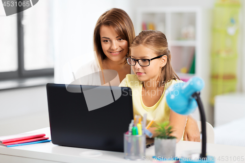 Image of mother and daughter with laptop doing homework