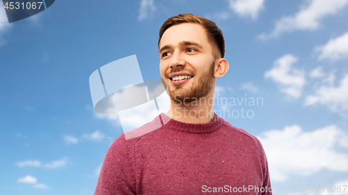 Image of smiling young man over blue sky background