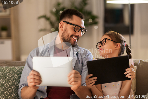 Image of father and daughter with tablet computers at home