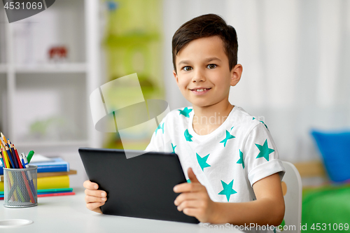 Image of student boy with tablet pc and notebook at home